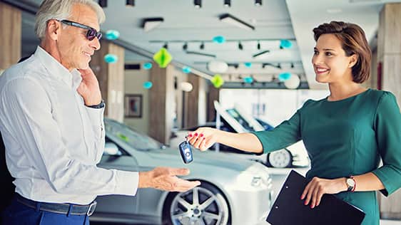 車のキーを男性に手渡す女性