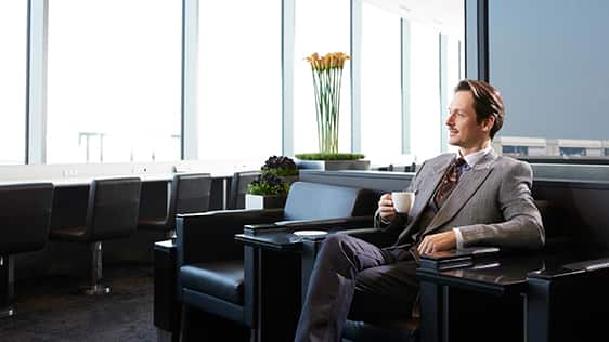 ラウンジでカップを持つ男性