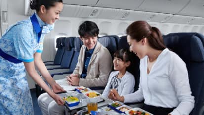 飛行機で食べ物を食べる家族