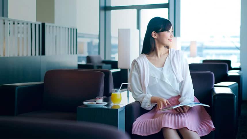 搭乗ゲートラウンジで待っている女性